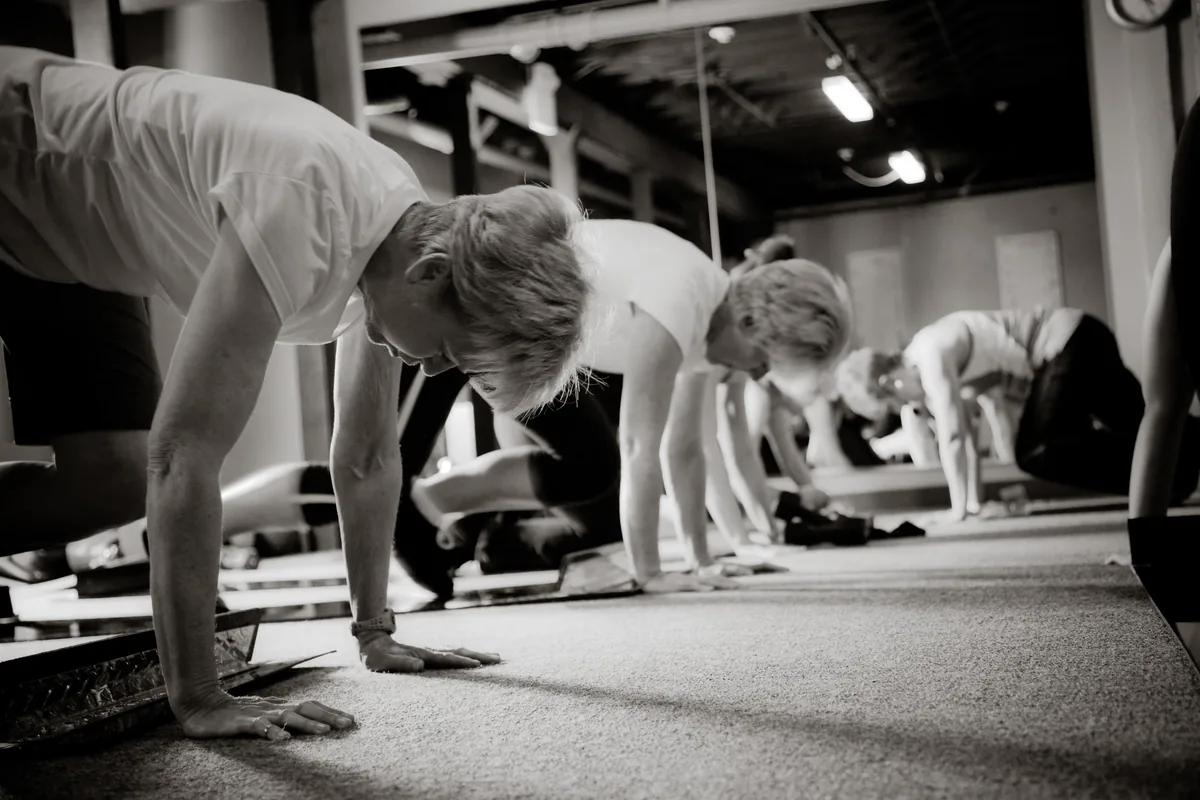 An Obsidian® I class holding a plank position along a row of slide boards
